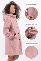 Woman wearing pink oversized Rain Couture Windbreaker with hood, stylish pockets, cuffed sleeves, and water-resistant fabric.