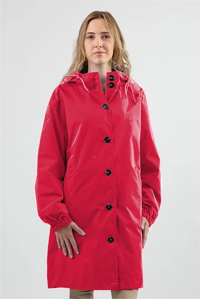 Woman wearing red oversized Rain Couture Windbreaker water-resistant jacket with hood and buttons.