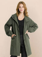 Trendy oversized Rain Couture Windbreaker in dark green, lightweight and water-resistant jacket with hood and pockets.