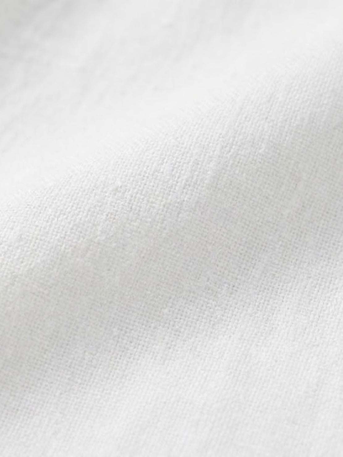 Close-up of soft white cotton fabric texture for cotton dress