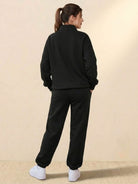 Woman wearing black ultra-soft and comfy co-ord tracksuit set with white sneakers, viewed from back