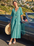 V-neck two-tiered maxi swing dress in flowing tiers with irregular hemline and draped sleeves, made from 100% cotton.