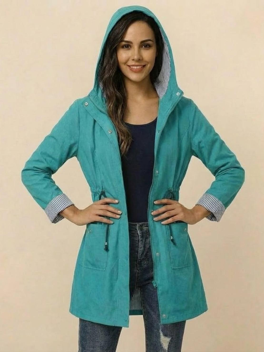woman wearing teal water resistant hooded striped windbreaker jacket with adjustable waist and pockets