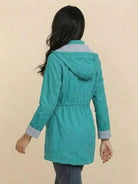 Women wearing teal water resistant windbreaker jacket with hood and striped lining back view