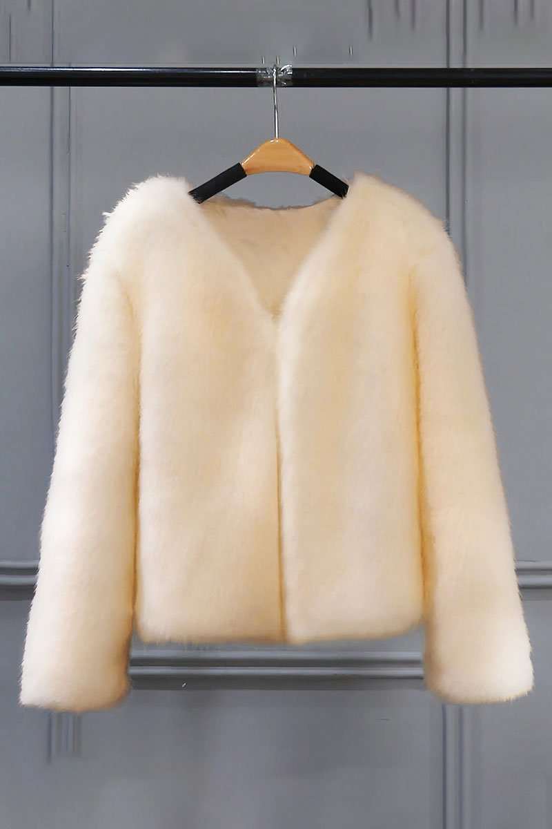 Cream bold faux fur luxe jacket with V neckline and button front closure hanging on wooden hanger